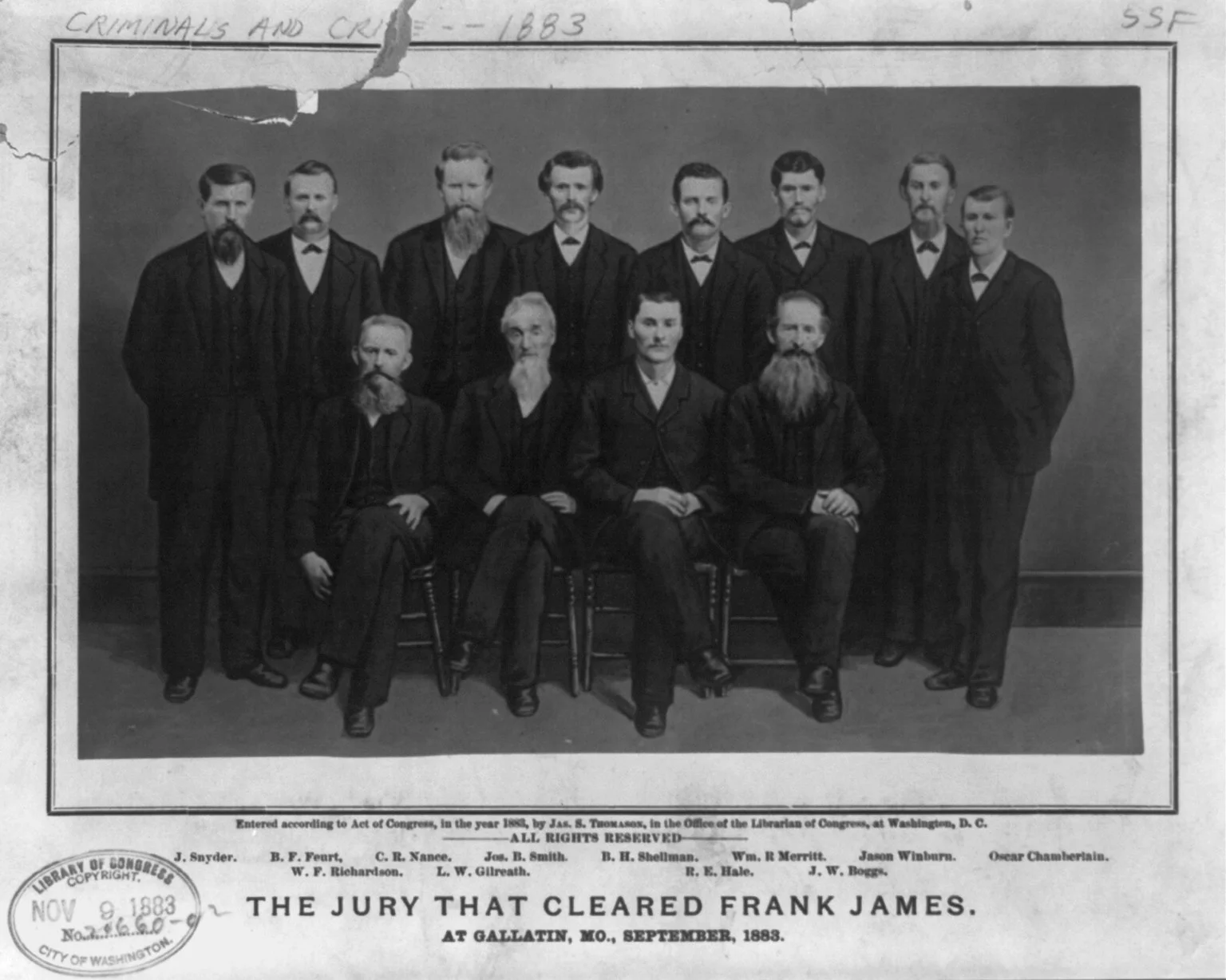Twelve men of an 1883 Missouri trial jury pose in three rows for a formal group portrait outside the courthouse.