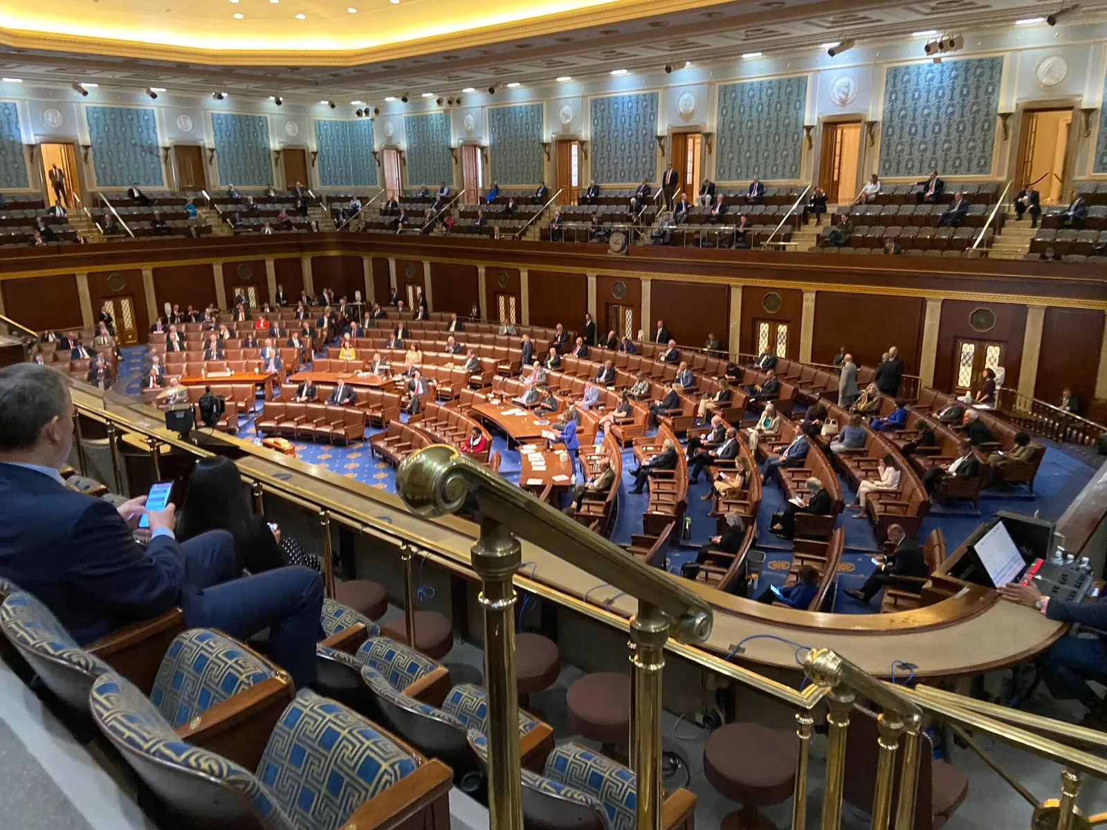 The chamber of the United States House of Representatives, with tiered semicircular desks facing the Speaker's rostrum and the national flag