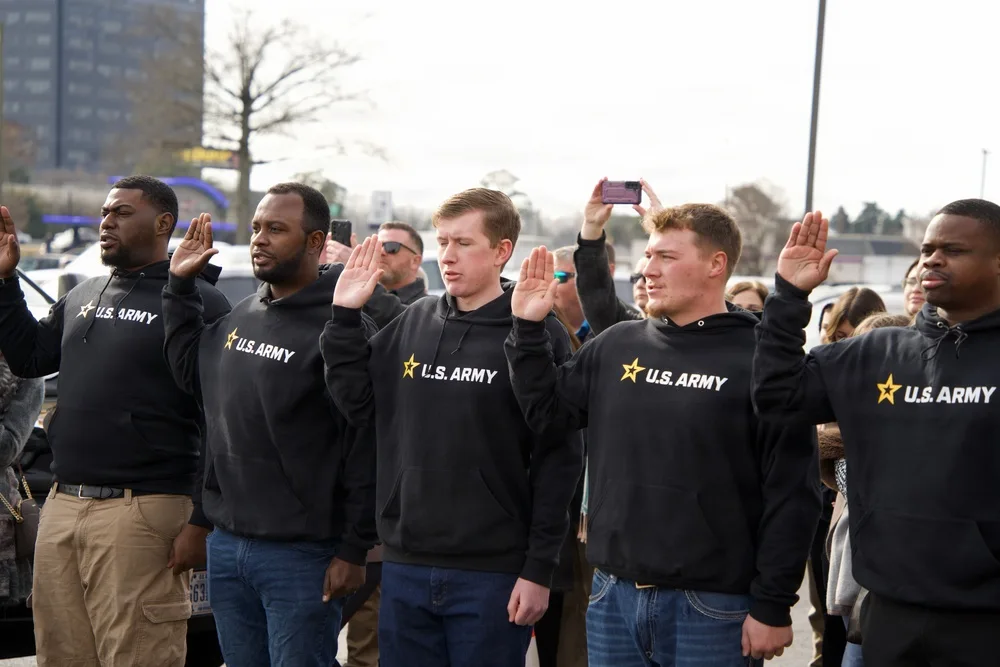 New recruits raise their right hands during a multi-service oath of enlistment ceremony