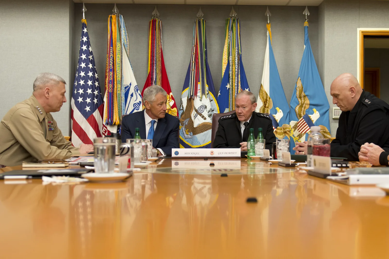 The Secretary of Defense and the Joint Chiefs of Staff seated around a long conference table in the Pentagon's secure meeting room known as the Tank.