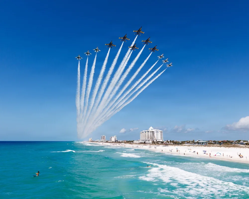 Navy Blue Angels and Air Force Thunderbirds fly a joint Super Delta formation over Pensacola Beach