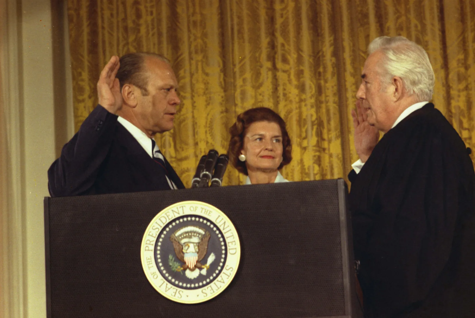 President Gerald R. Ford takes the oath of office from Chief Justice Warren Burger in the East Room of the White House, becoming the 38th president after Richard Nixon's resignation, August 9, 1974.
