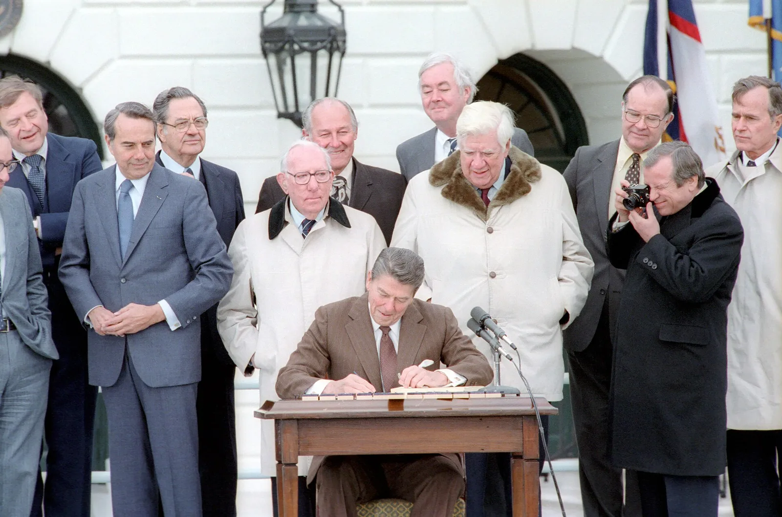 President Reagan signing the Social Security Amendments of 1983 on the South Lawn of the White House, April 20, 1983, flanked by bipartisan congressional leaders