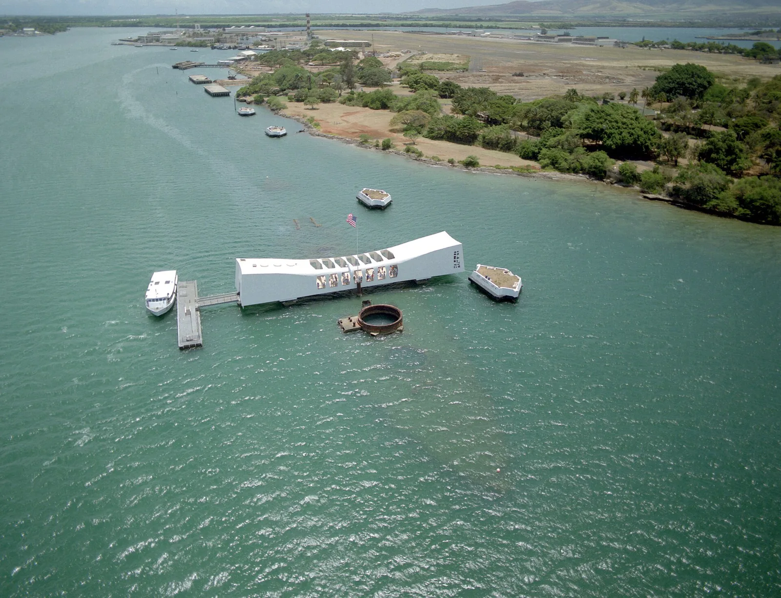 The USS Arizona Memorial at Pearl Harbor rising above the harbor waters, marking the resting place of 1,177 sailors killed in the December 7, 1941 attack that drew America into World War II