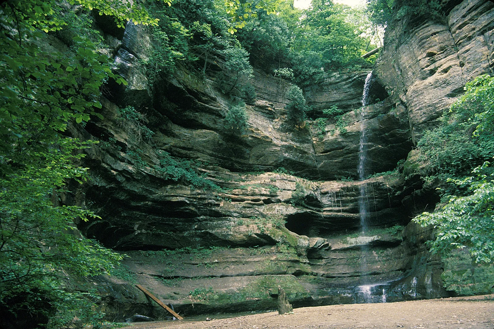 Waterfall cascading down sandstone canyon walls at Starved Rock State Park, Illinois
